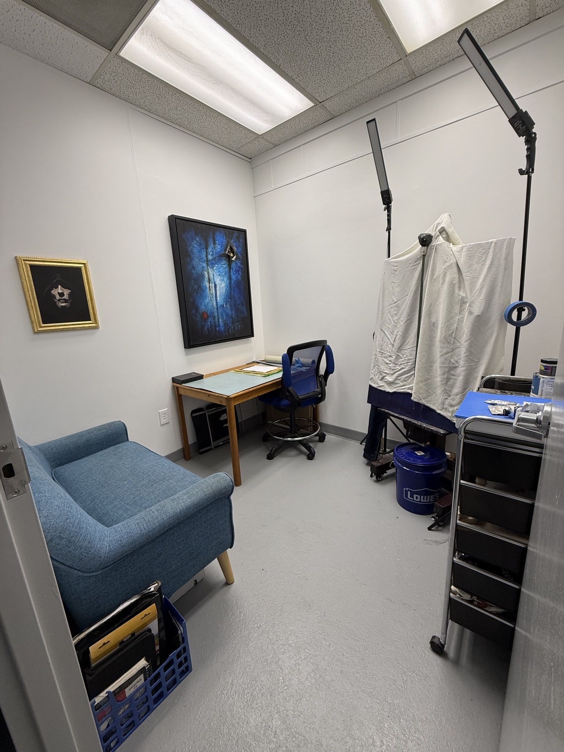 Inside Jeffery Bradford’s studio, with original paintings, an easel, and art materials